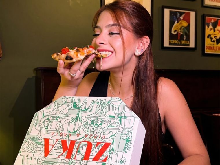 Cliente comendo a pizza da ZUKA